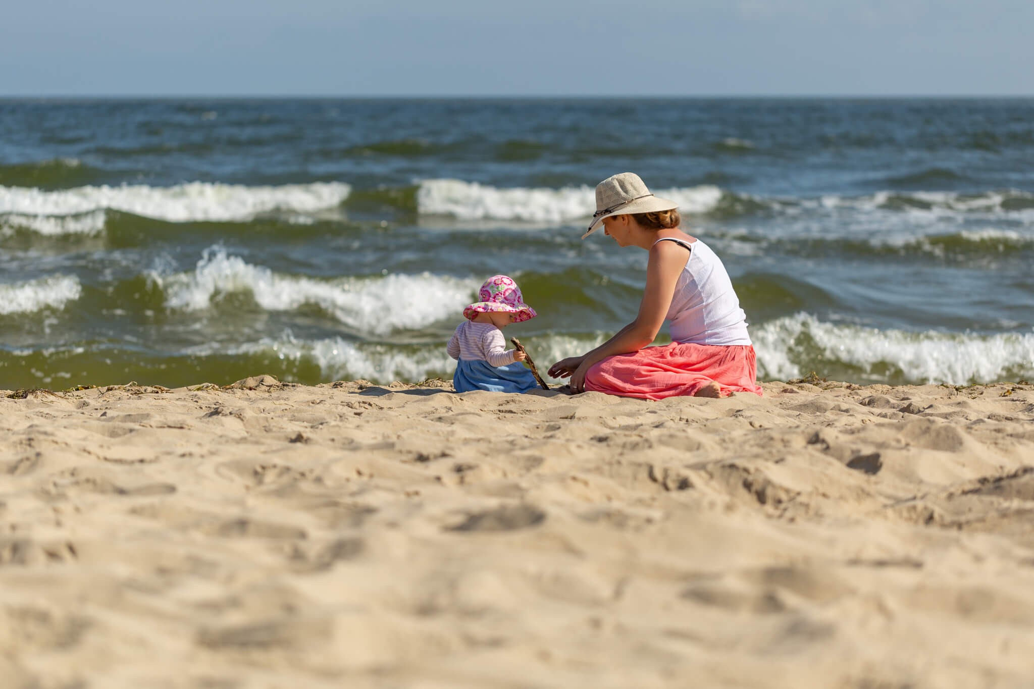 Mutter spielt mit Kind am Strand