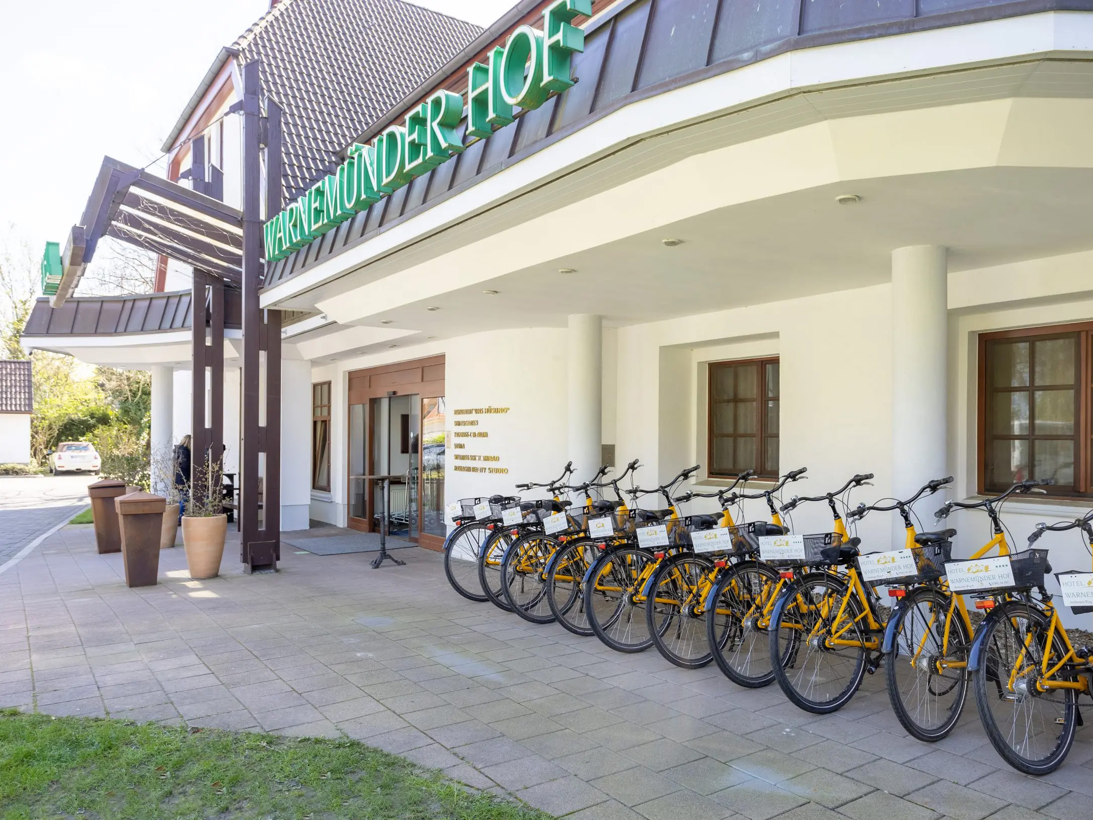 Das Bild zeigt den Haupteingang vom 4-Sterne-Hotel Warnemünder Hof mit eigenem Fahrradverleih.